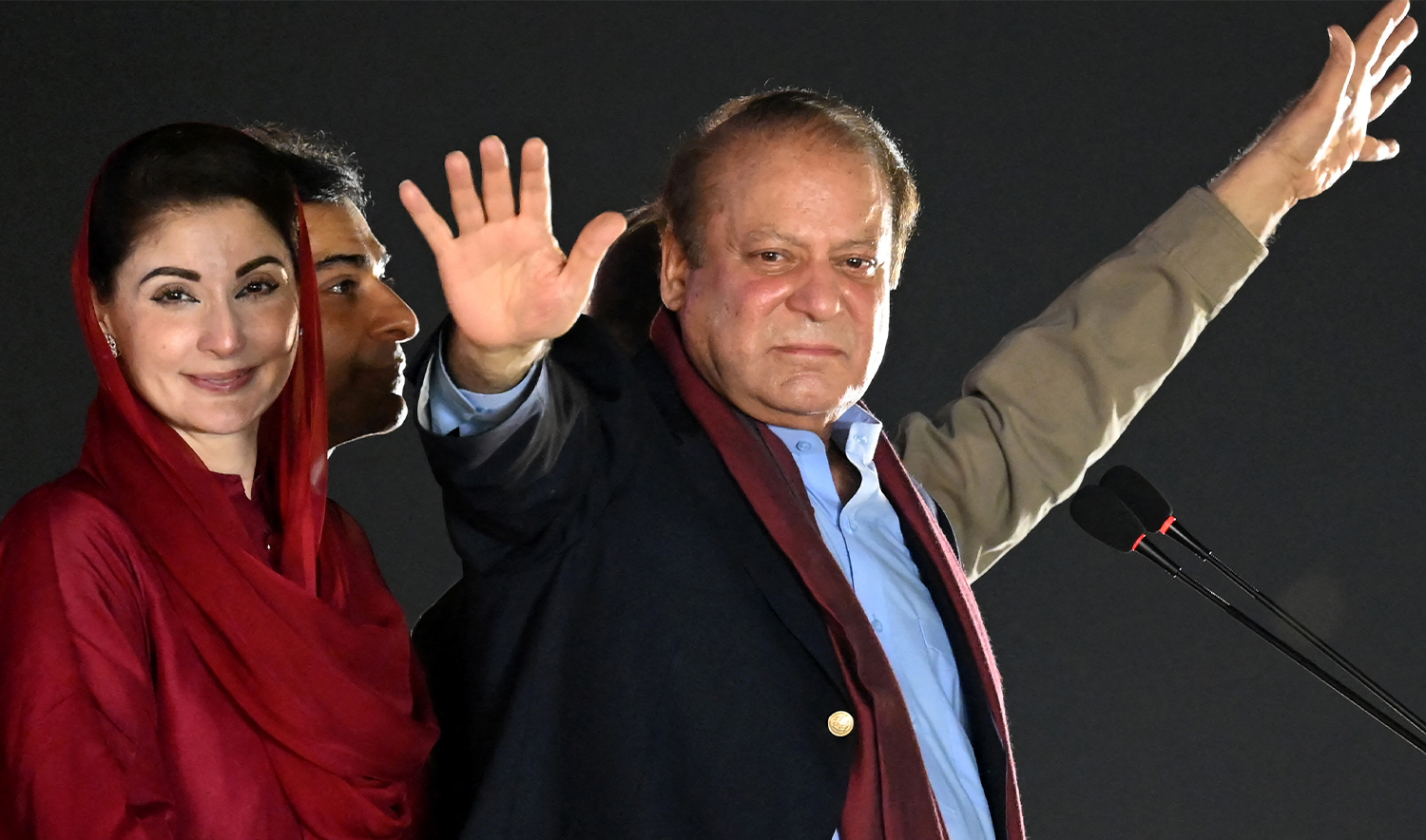 Pakistan's former Prime Minister Nawaz Sharif (R) stands beside his daughter Maryam Nawaz (L) as he waves to their supporters along with his brother and former Prime Minister Shehbaz Sharif (back) gathered at a park during an event held to welcome him in Lahore on October 21, 2023. (AFP/File)