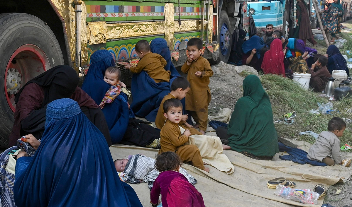 Afghan refugees wait near the United Nations High Commissioner for Refugees (UNHCR) Azakhel Voluntary Repatriation Centre in Nowshera on October 30, 2023. (AFP)