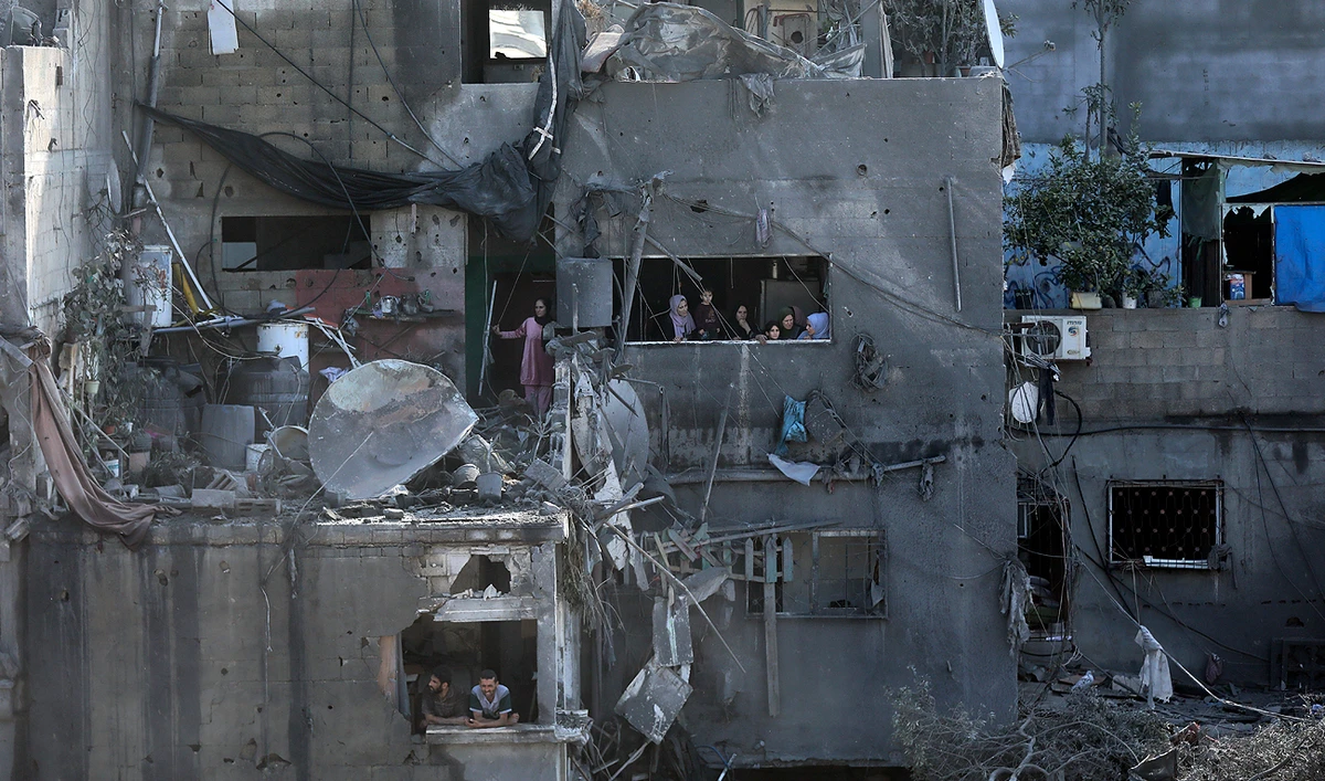 Palestinians look from windows at the damage caused by Israeli airstrikes in Jabaliya refugee camp, northern Gaza Strip on November 1, 2023. (AP)