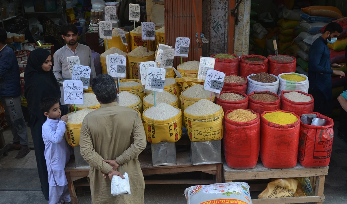 People buy pulses and grains at a wholesale market in Karachi on February 1, 2023. (AFP/File)