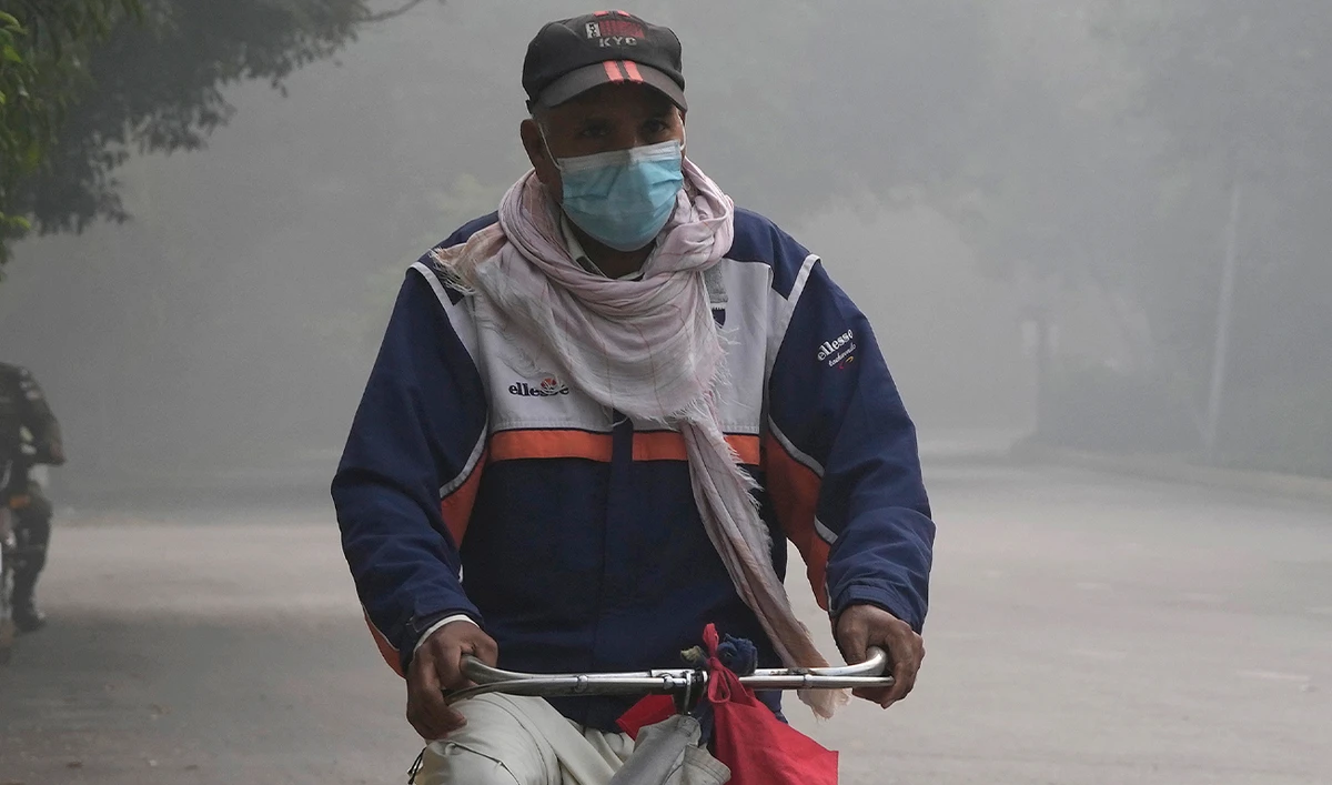 A cyclist wears mask to head to his work-point as smog envelops the areas of Lahore, Pakistan, on November 8, 2023. (AP)