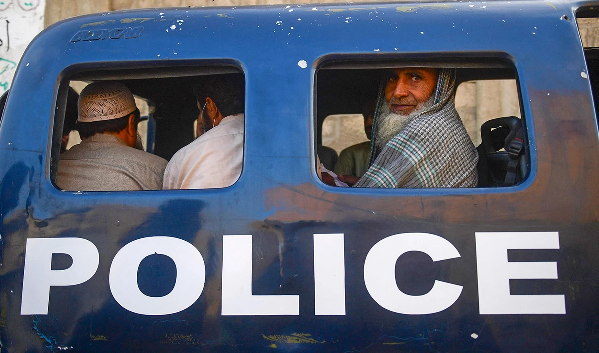 Detained Afghan refugees sit in a van during a search operation to identify alleged illegal immigrants, on the outskirts of Karachi on November 17, 2023. (AFP)