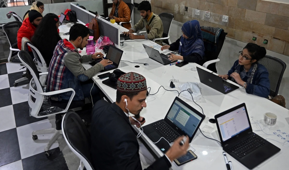 In this picture taken on January 8, 2022, employees of Taza Transforming Agriculture talk with customers at a call centre in Lahore, Pakistan. (AFP/File)