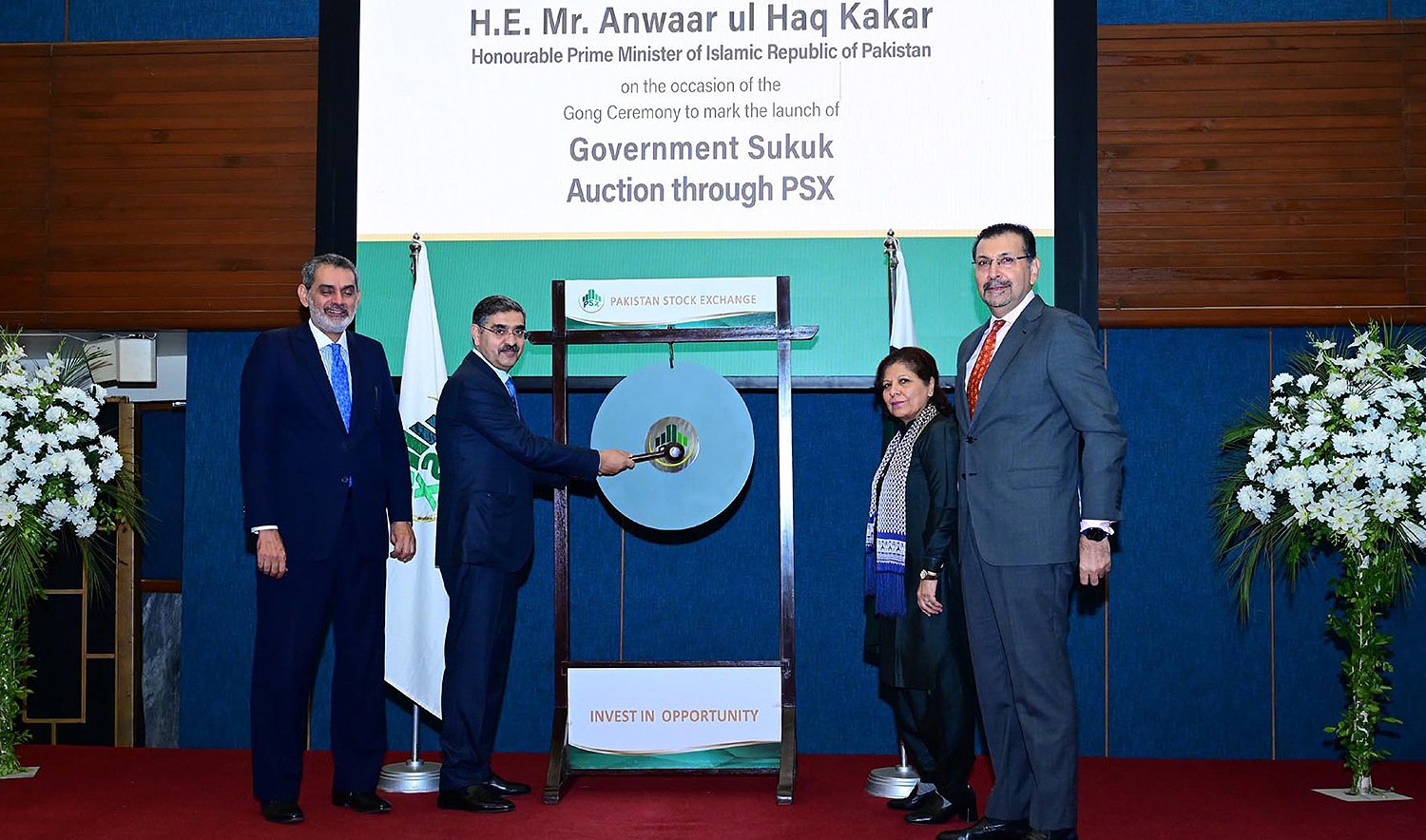 Pakistan's Prime Minister Anwaar-ul-Haq Kakar (second left) strikes a gong to mark the launch of Sukuk bond at the Pakistan Stock Exchange in Karachi, Pakistan, on December 8, 2023. (PID)