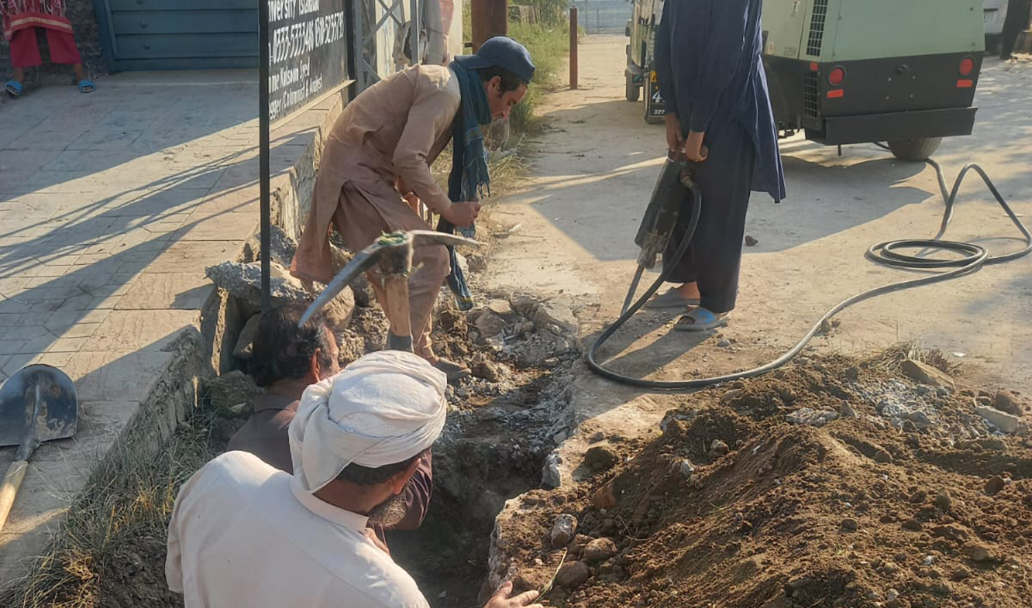 Workers from Sui Northern Gas Pipeline Limited excavate the road to eliminate a 1.5-kilometer illegal gas pipeline in Islamabad, Pakistan on December 8, 2023. (Photo courtesy: Shahid Akram)