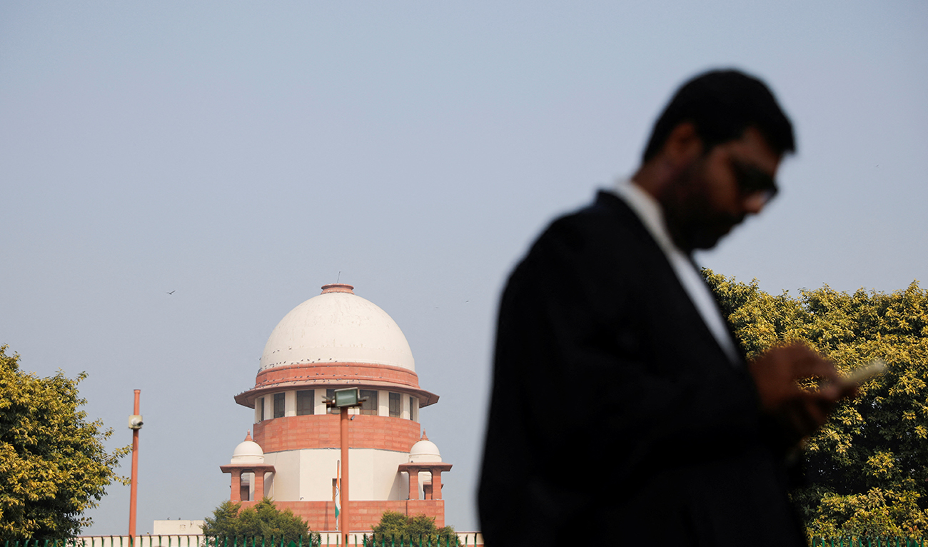 A lawyer looks into his mobile phone in front India's Supreme Court in New Delhi, December 11, 2023. (Reuters)