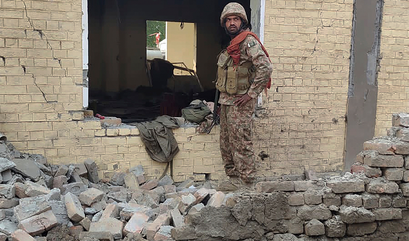 An army soldier examines damages on the site of a bombing at a police station on the outskirts of Dera Ismail Khan, Pakistan, on December 12, 2023. (AP)