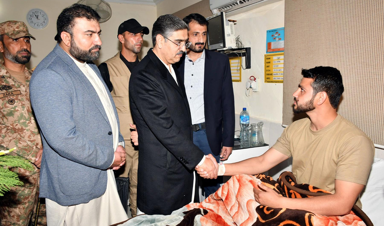Pakistan Prime Minister Anwaar-ul-Haq Kakar (second left) shakes hands with a soldier injured in a militant attack at a military checkpoint in Darban town the day before, in Dera Ismail Khan, Pakistan, on December 13, 2023. (PID)