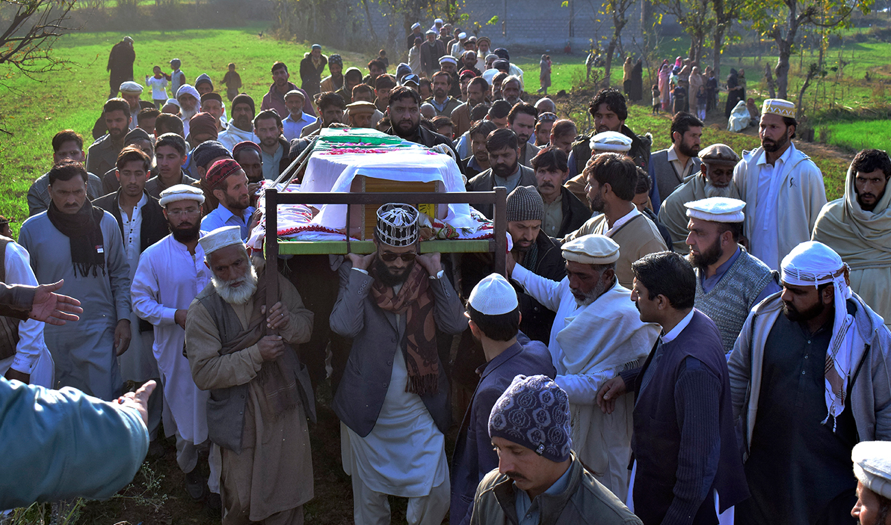 Villagers carry a casket of an army soldier, who was killed in Tuesday's suicide bombing, for funeral prayer in Chitta Batta village near Mansehra, Pakistan, on December 13, 2023. (AP)