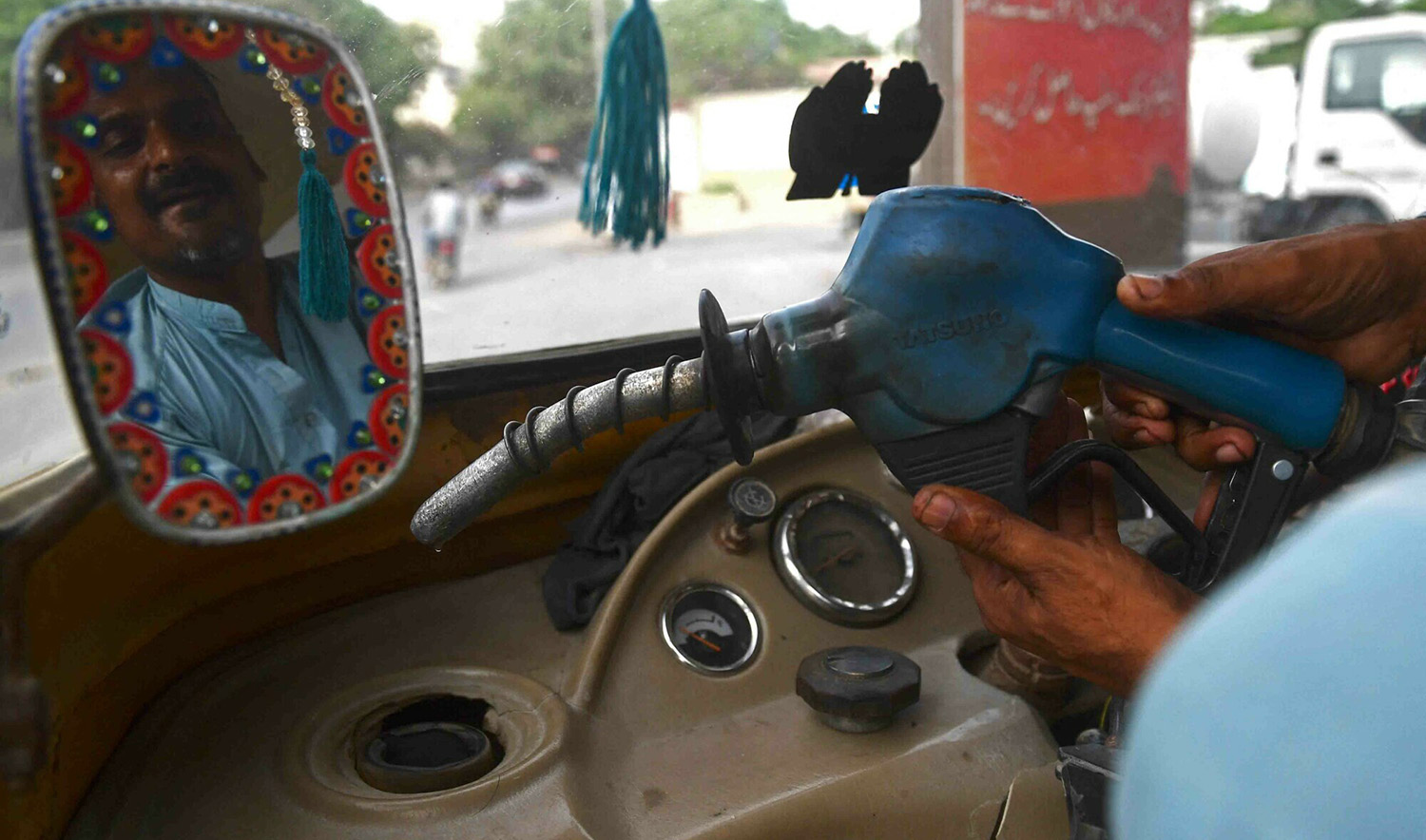 A man fills petrol in his rickshaw at a fuel station in Karachi, Pakistan on August 16, 2023. (AFP/File)