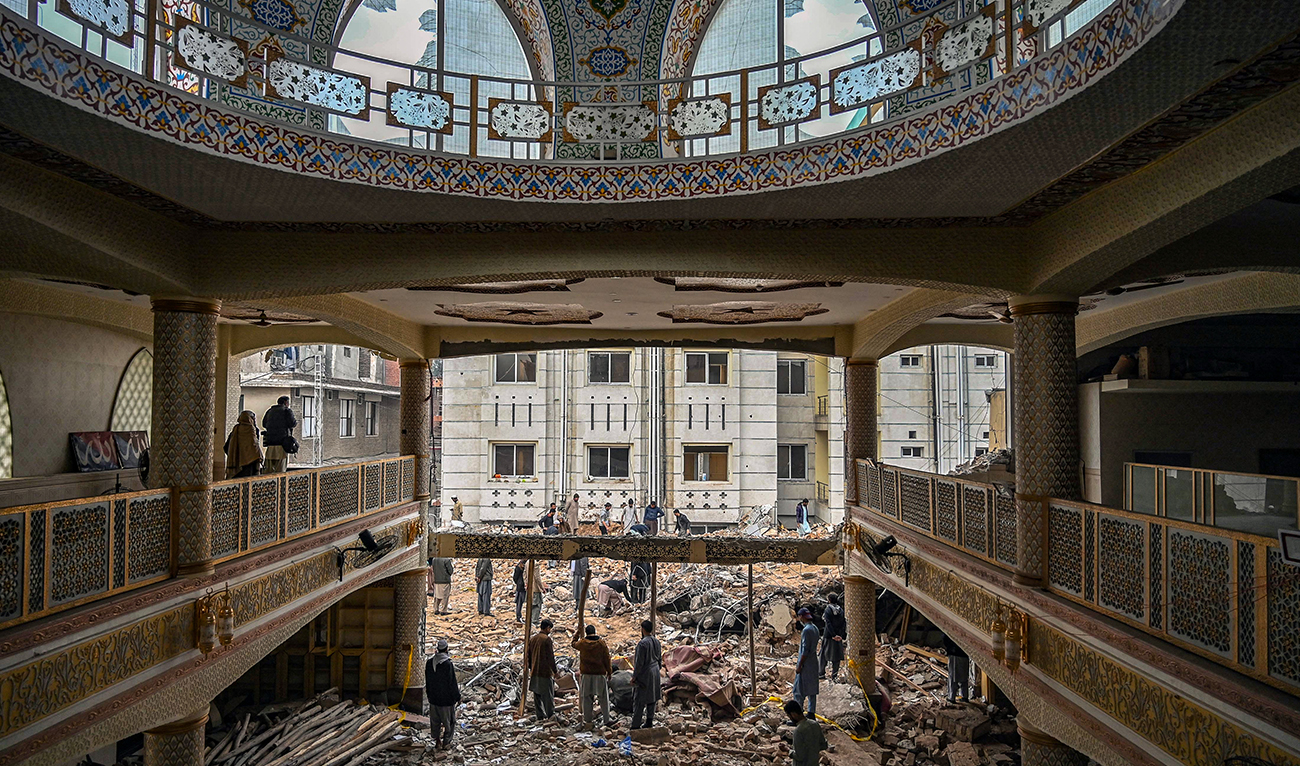 Plain-clothed policemen gather over the rubble of a damaged mosque following January's 30 suicide blast inside the police headquarters in Peshawar on February 1, 2023. (AFP/File)