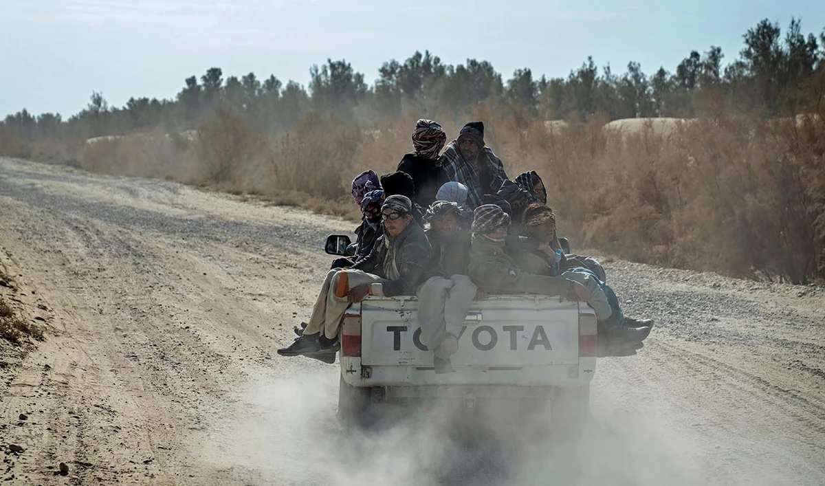 Afghan refugees sit in the back of a truck to go to Iran through the desert after crossing the borders of Afghanistan and Pakistan, on the outskirts of Zaranj city, Afghanistan, Sunday, Dec. 24, 2023. (AP)