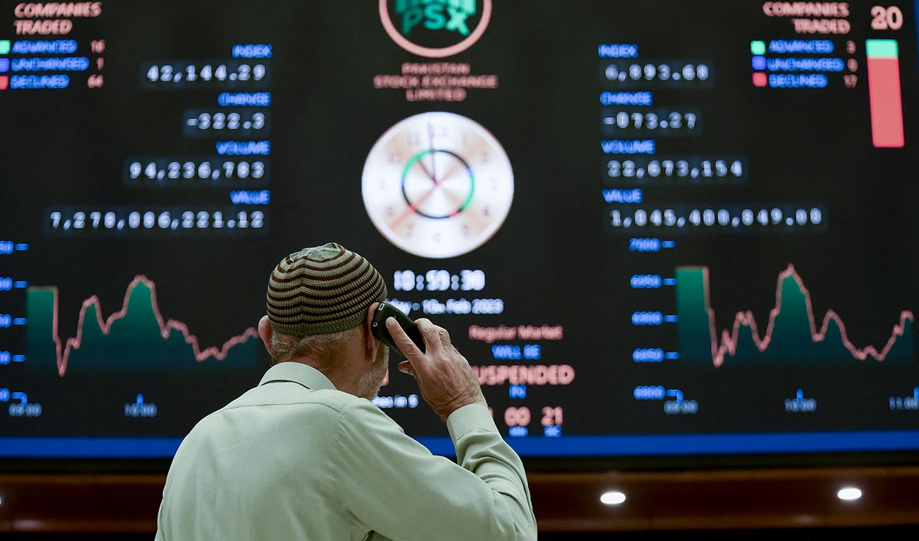 A broker talks on phone as he looks an index board showing the latest share prices at the Pakistan Stock Exchange in Karachi on February 10, 2023. (AFP/File)