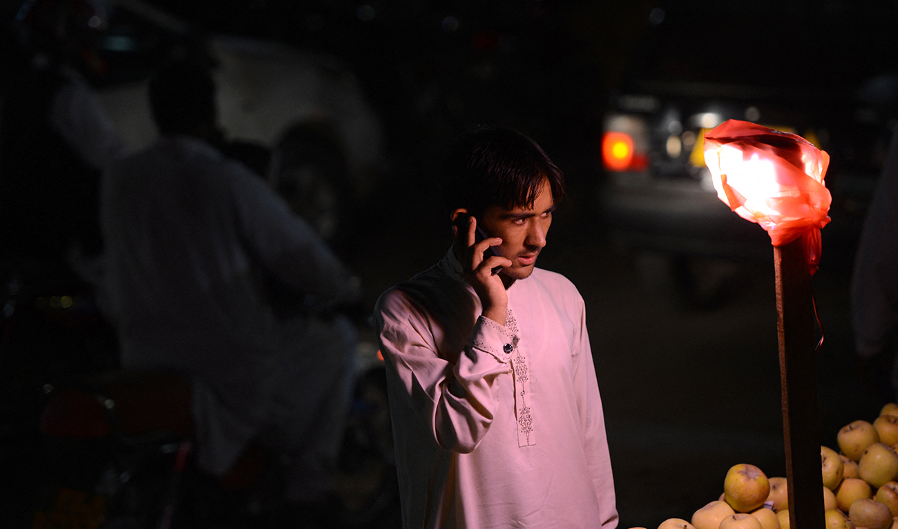 In this photograph taken on September 9, 2013, a Pakistani boy talks on his mobile phone at a market in Islamabad. (AFP)