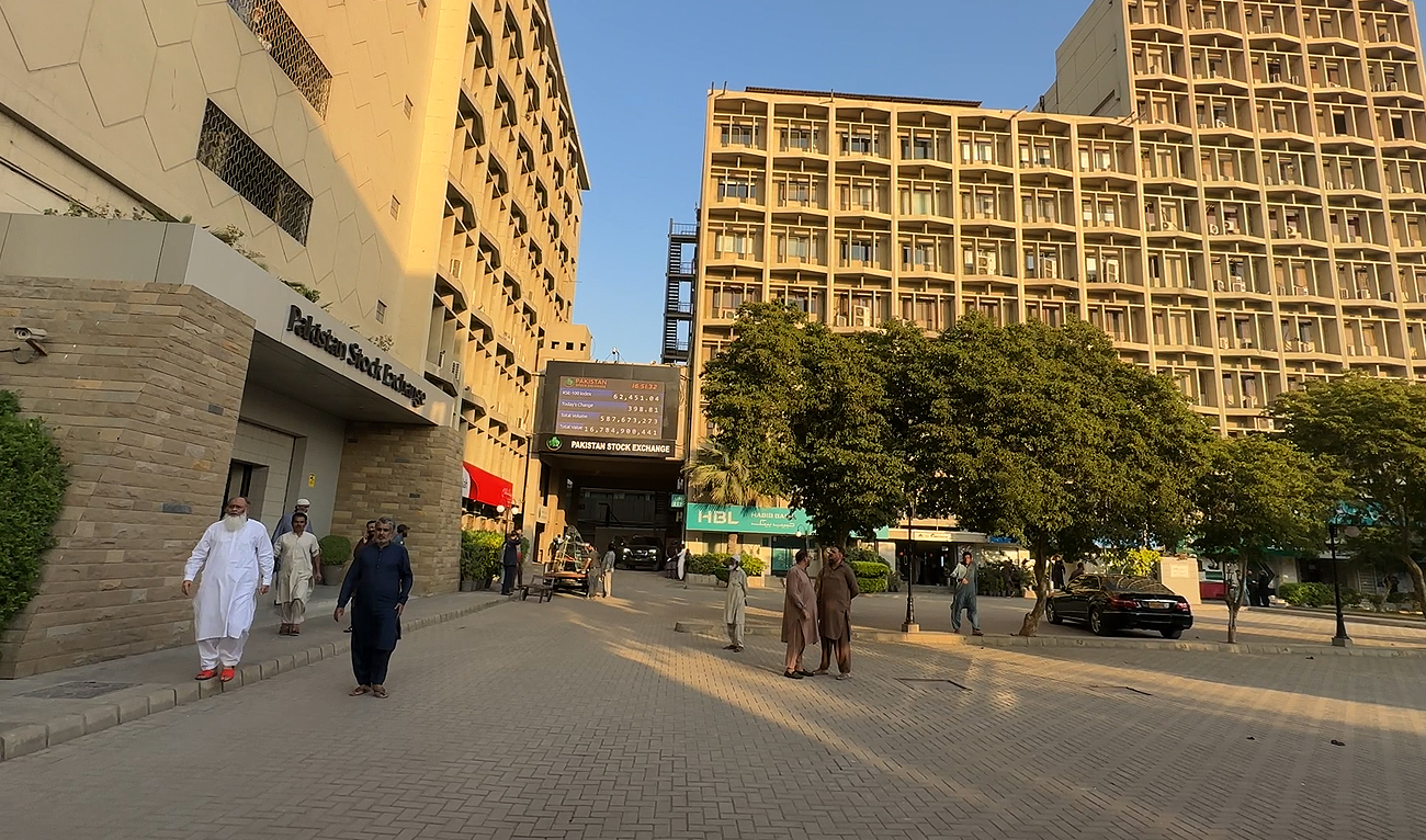 In this photo, taken on December 29, 2023, workers walk past the Pakistan Stock Exchange building in Karachi. (AN Photo/File)