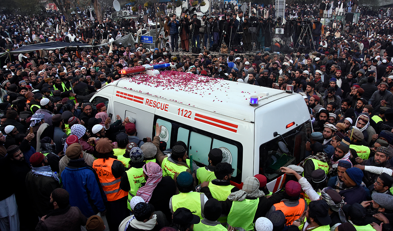People gather around the ambulance carrying the casket of Pakistani Sunni Muslim cleric Masoodur Rehman Usmani, following his funeral prayer, in Islamabad, Pakistan, Sunday, Jan. 6, 2024. (AP)