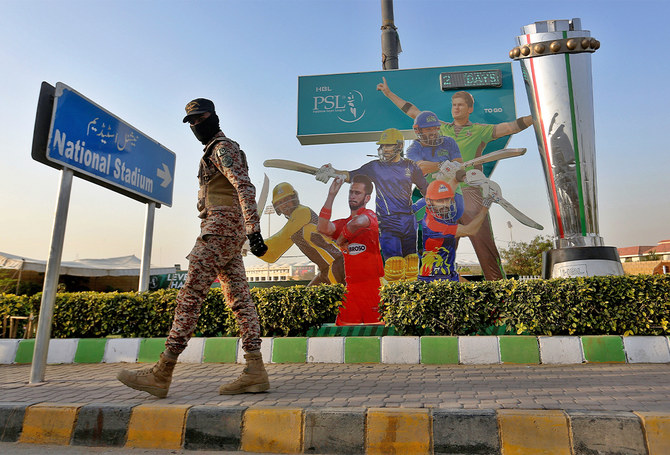 A paramilitary soldier patrols next to cutouts of cricket players displaying outside the National Stadium for the upcoming country's premier domestic Twenty20 tournament 'Pakistan Super League' in Karachi, Pakistan, on January 25, 2022. (AP/File)