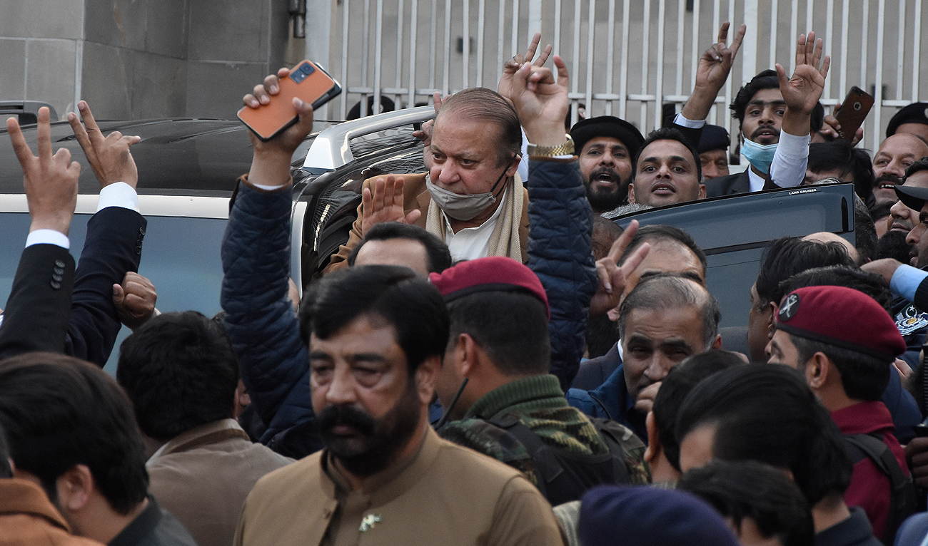 In this file photo, taken on December 12, 2023, Pakistan's former Prime Minister Nawaz Sharif (center) waves to his supporters as he leaves after a court hearing in Islamabad. (AP/File)