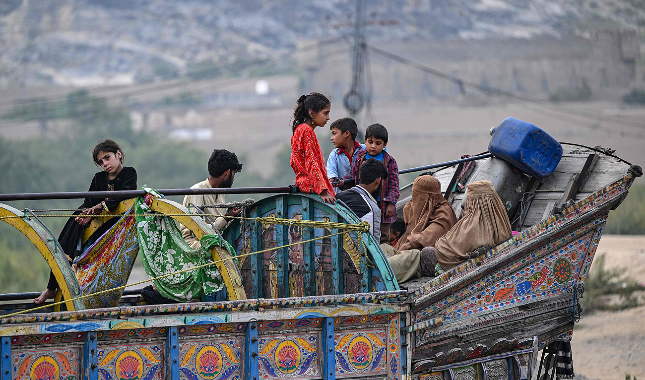 In this file photo, taken on November 1, 2023, Afghan refugees arrive in a truck at a holding centre as they prepare to depart for Afghanistan, in Landi Kotal. (AFP/File)
