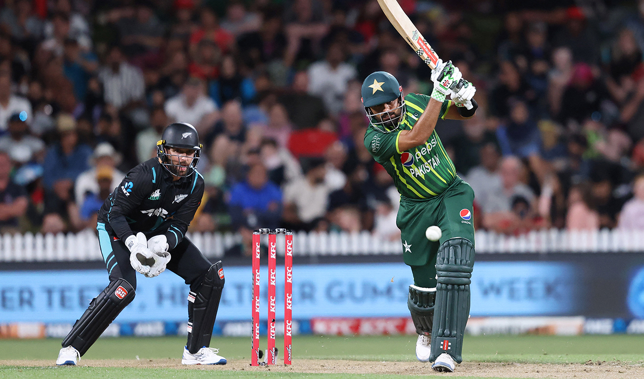 Pakistan's Babar Azam bats while being watched by New Zealand wicketkeeper Devon Conway (L) during the second Twenty20 international cricket match between New Zealand and Pakistan at Seddon Park in Hamilton on January 14, 2024. (AFP)