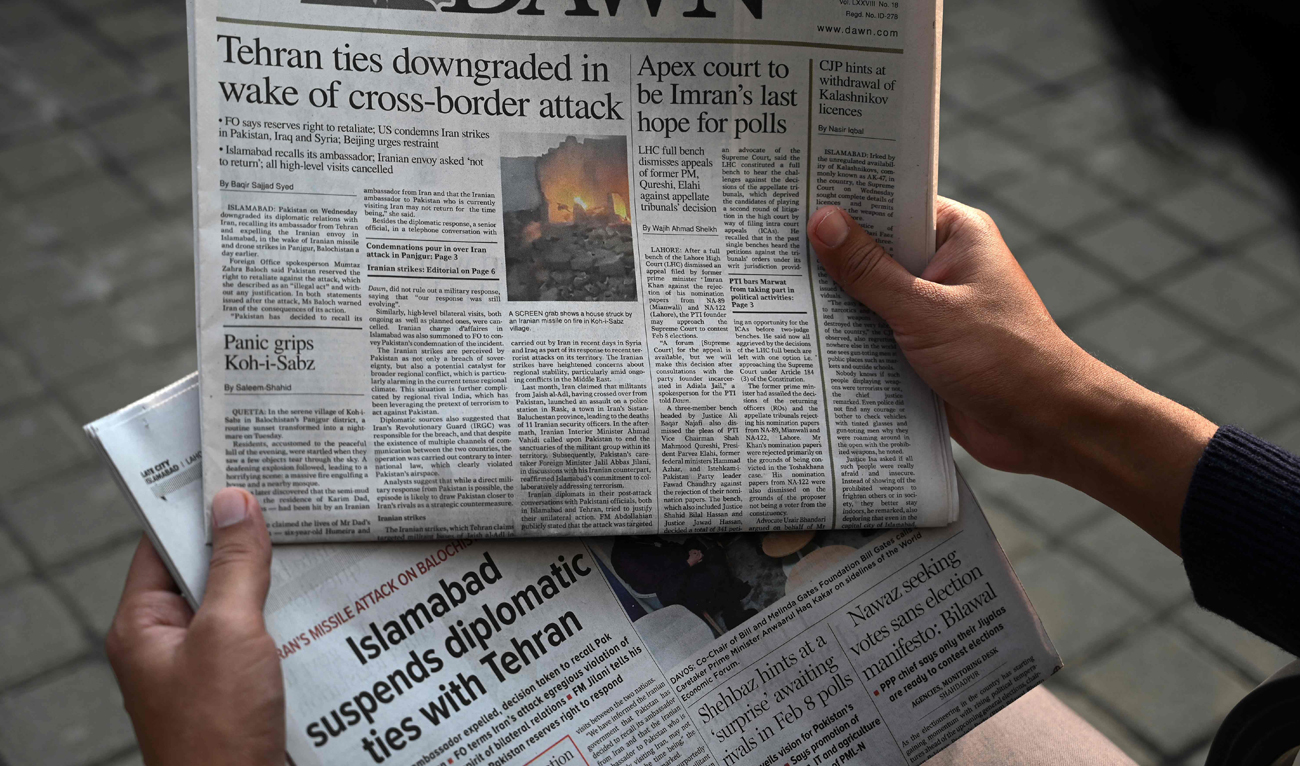 A man reads the frontpage of the Pakistani English-language newspaper Dawn displaying news on Iran's airstrike, in Islamabad on January 18, 2024. (AFP)