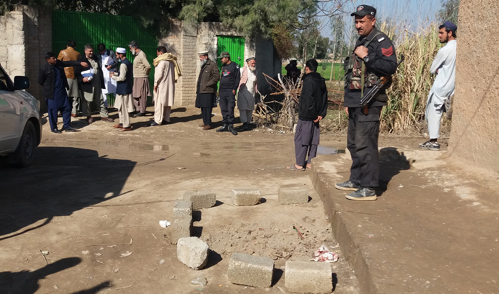 Police officials gather at the site of an attack by gunmen on a policeman guarding a polio vaccination team in Kohat, some 75 kms southwest of Peshawar on January 25, 2022. (AFP/File)