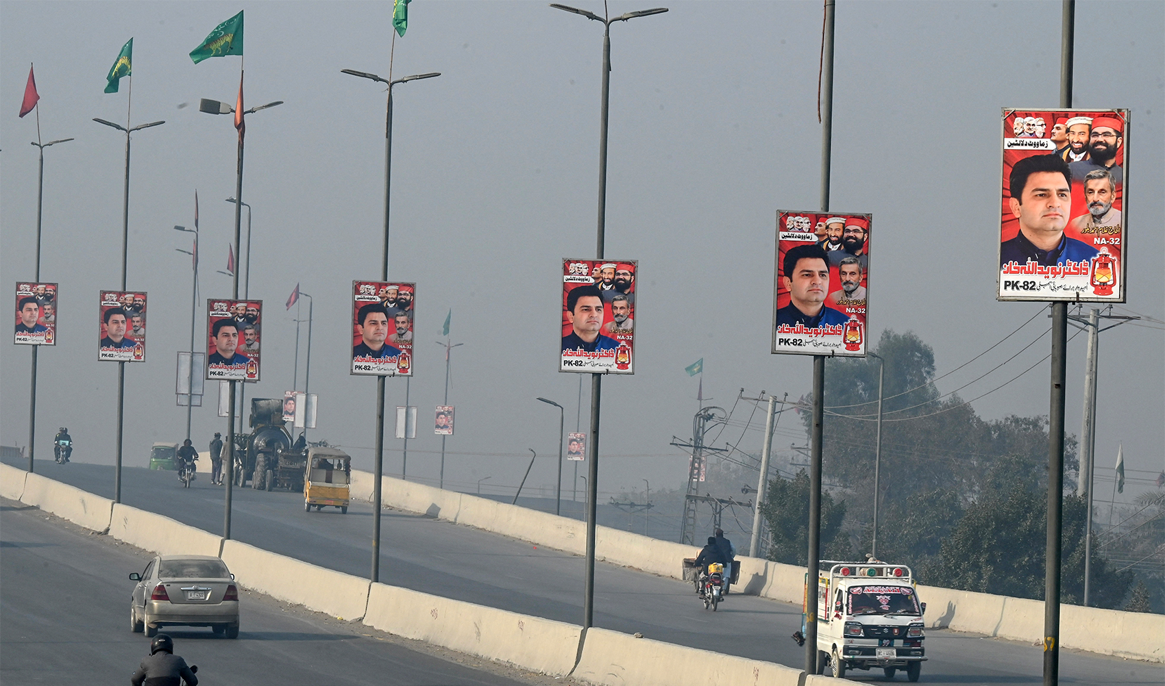 Election posters installed on light poles along a road in Peshawar on December 22, 2023, ahead of Pakistan's general elections. (AFP/File)