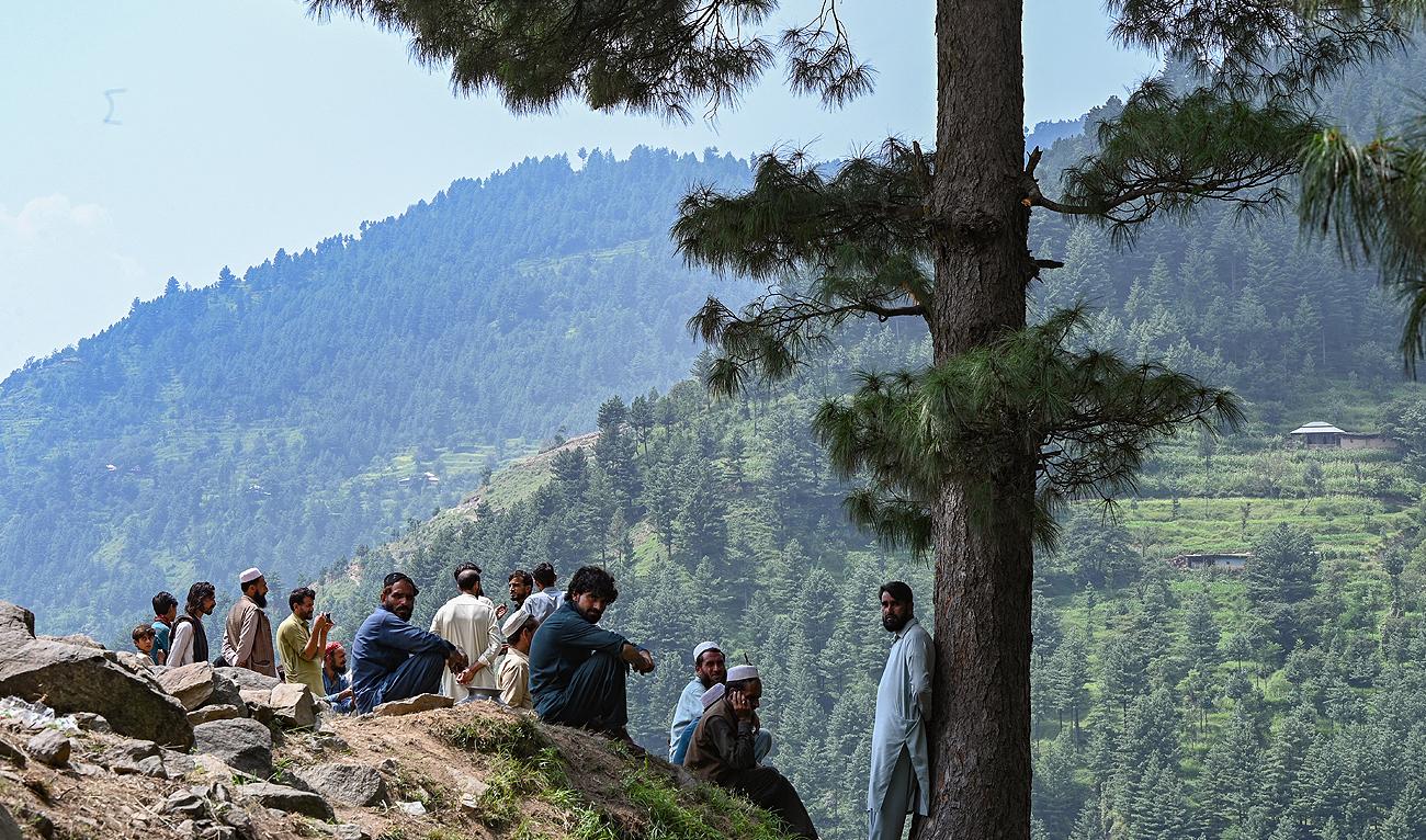 In this file photo, taken on August 23, 2023, people gesture for a photograph at the Pashto village of mountainous Khyber Pakhtunkhwa province. (AFP/File)