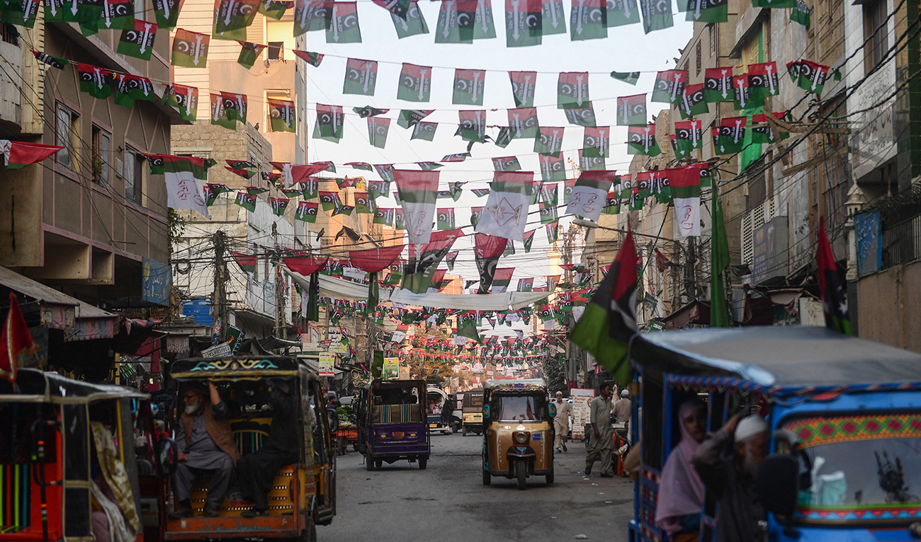 Commuters move past the Pakistan People's Party (PPP) flags hung over a street in Karachi on January 16, 2024, ahead of the country’s upcoming general elections. (AFP/File)