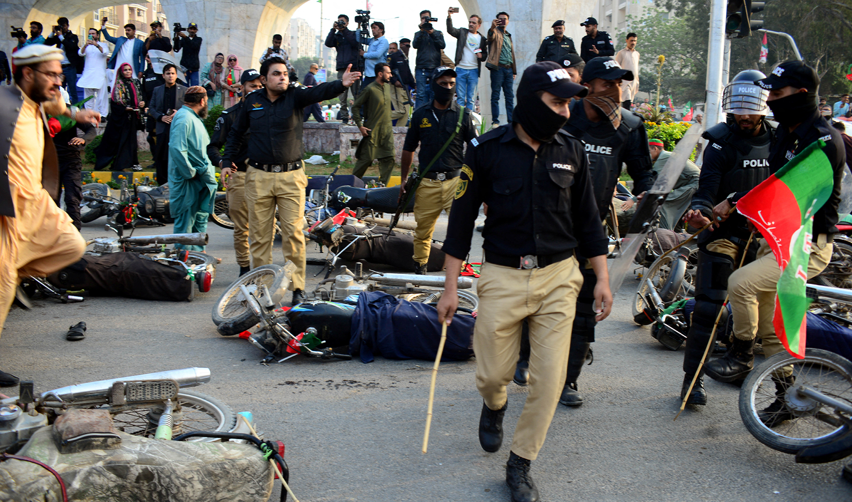 Police officers gesture next to fallen motorbikes of supporters of former prime minister Imran Khan's party, the Pakistan Tehreek-e-Insaf (PTI), during a clash at a rally ahead of a general election, in Karachi, Pakistan, on January 28, 2024. (REUTERS)