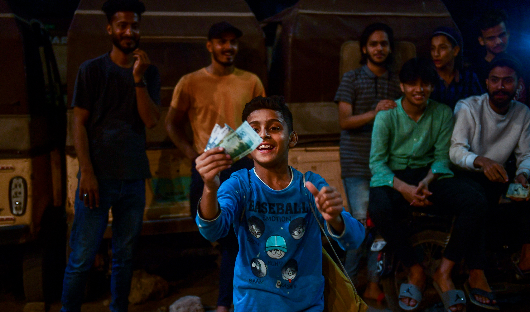In this picture taken on April 11, 2023, a young supporter of the winning team hold prize money after the tape ball night cricket tournament in Karachi, Pakistan. (AFP/File)