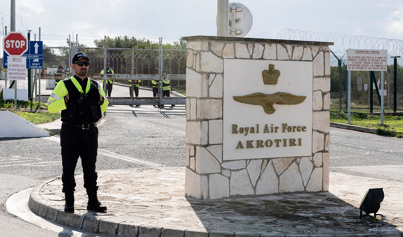 Police officers stand guard at the gates of the Royal Air Force Akrotiri base, a British overseas territory near the Cypriot coastal city of Limassol. (AFP/File)