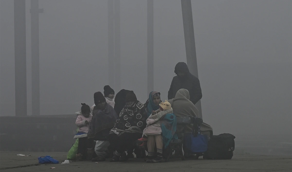 Passengers wait for a train at a railway station amid heavy smog conditions in Lahore January 17, 2024. (AFP/File)