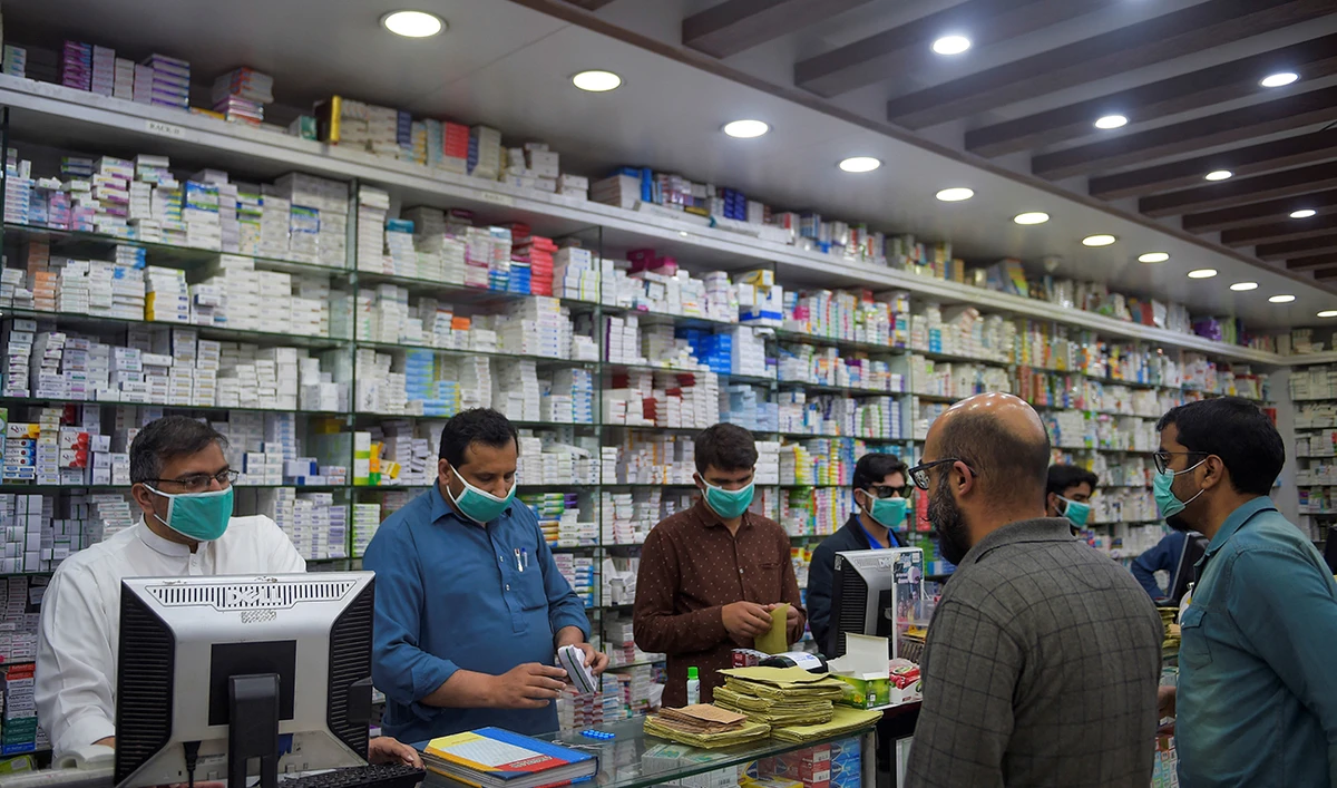 Pharmacy employees wearing facemasks as a preventive measure against the COVID-19 coronavirus attend to customers in Islamabad on March 23, 2020. (AFP/File)