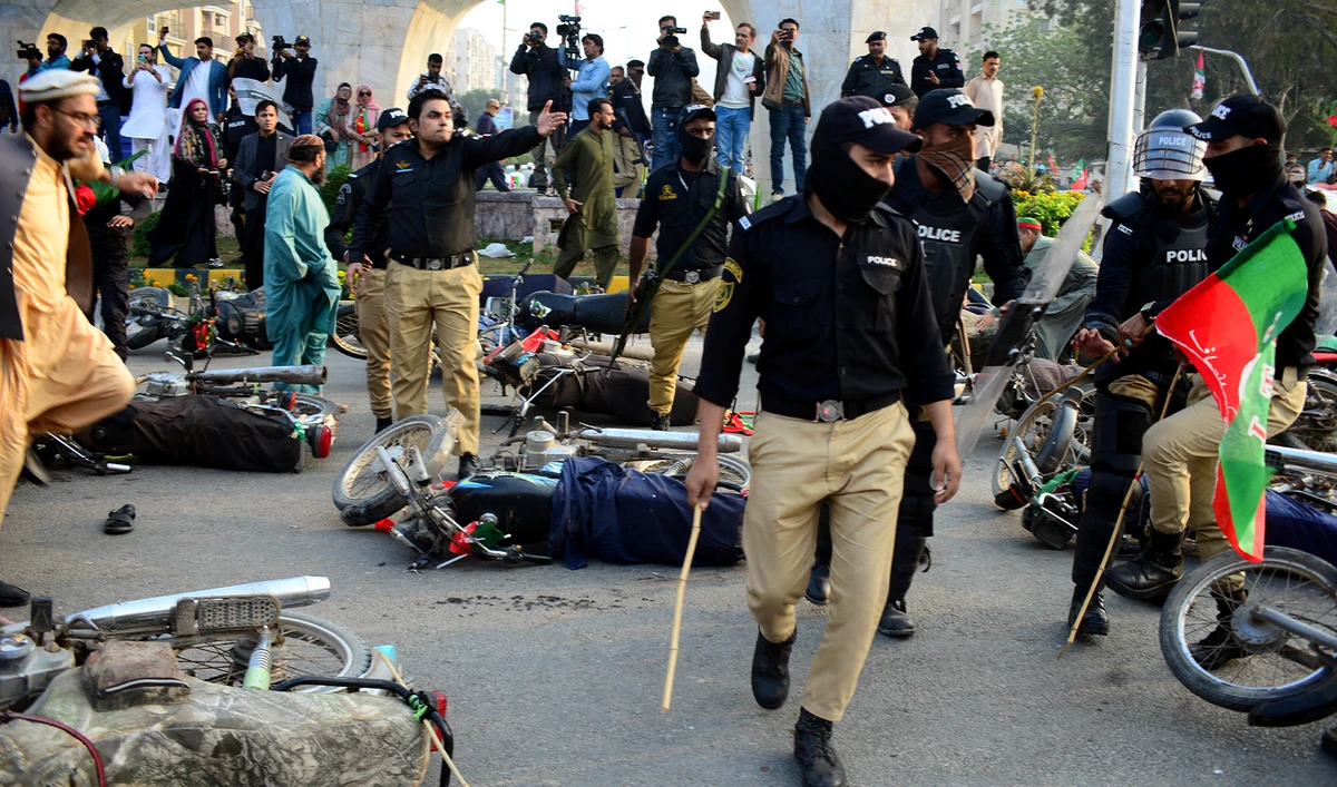 Police officers gesture next to fallen motorbikes of supporters of former prime minister Imran Khan's party, the Pakistan Tehreek-e-Insaf (PTI), during a clash at a rally ahead of a general election, in Karachi, Pakistan, on January 28, 2024. (REUTERS)