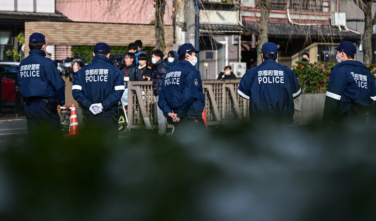 Police stand in a line as members of the media (behind) gather outside the Kyoto District Court in Kyoto on January 25, 2024. (AFP/File)