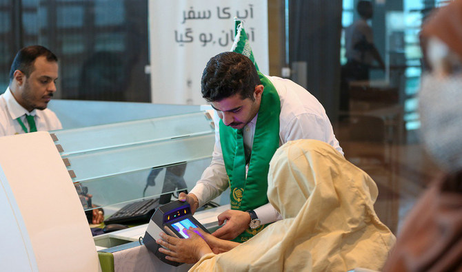 In this file photo, taken on June 13, 2023, a Saudi official facilitates Pakistani Hajj pilgrim during biometrics at the immigration counter on the Makkah Route counter set up at the Islamabad International Airport. (Photo courtesy: X/@MakkahRoute/File)