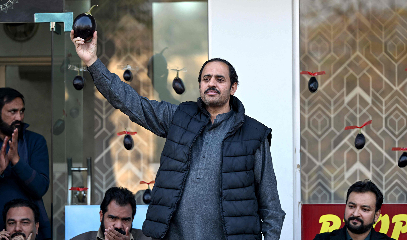 This photograph taken on January 26, 2024 shows Aamir Mughal (C), member of Pakistan Tehreek-e-Insaf (PTI) party and an independent election candidate for the national assembly, holding his electoral symbol 'eggplant' during an election campaign meeting in Islamabad. (AFP)