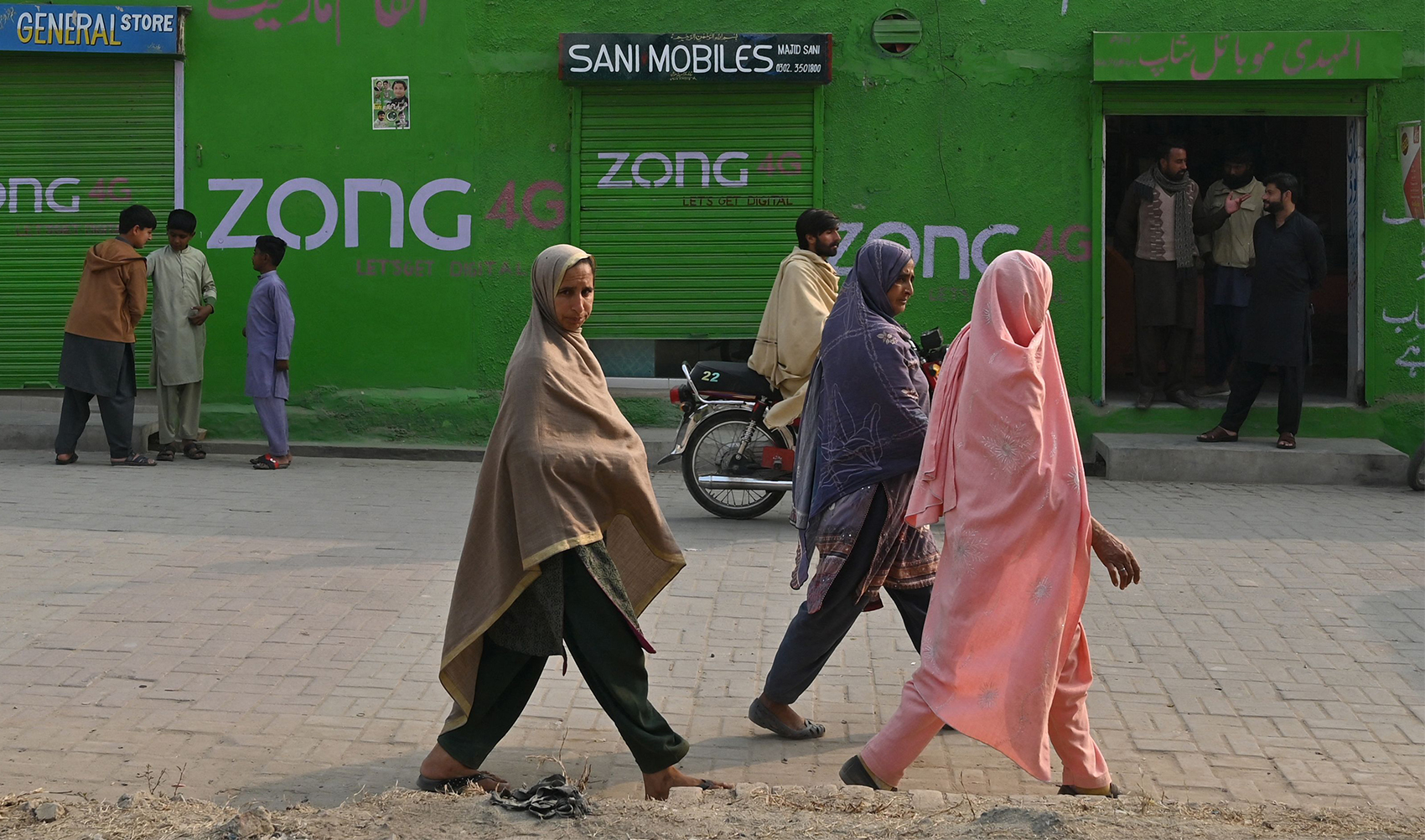 In this photograph taken on January 29, 2024, women look on as they walk along a street in Dhurnal of Punjab Province, ahead of the upcoming general elections. (AFP)