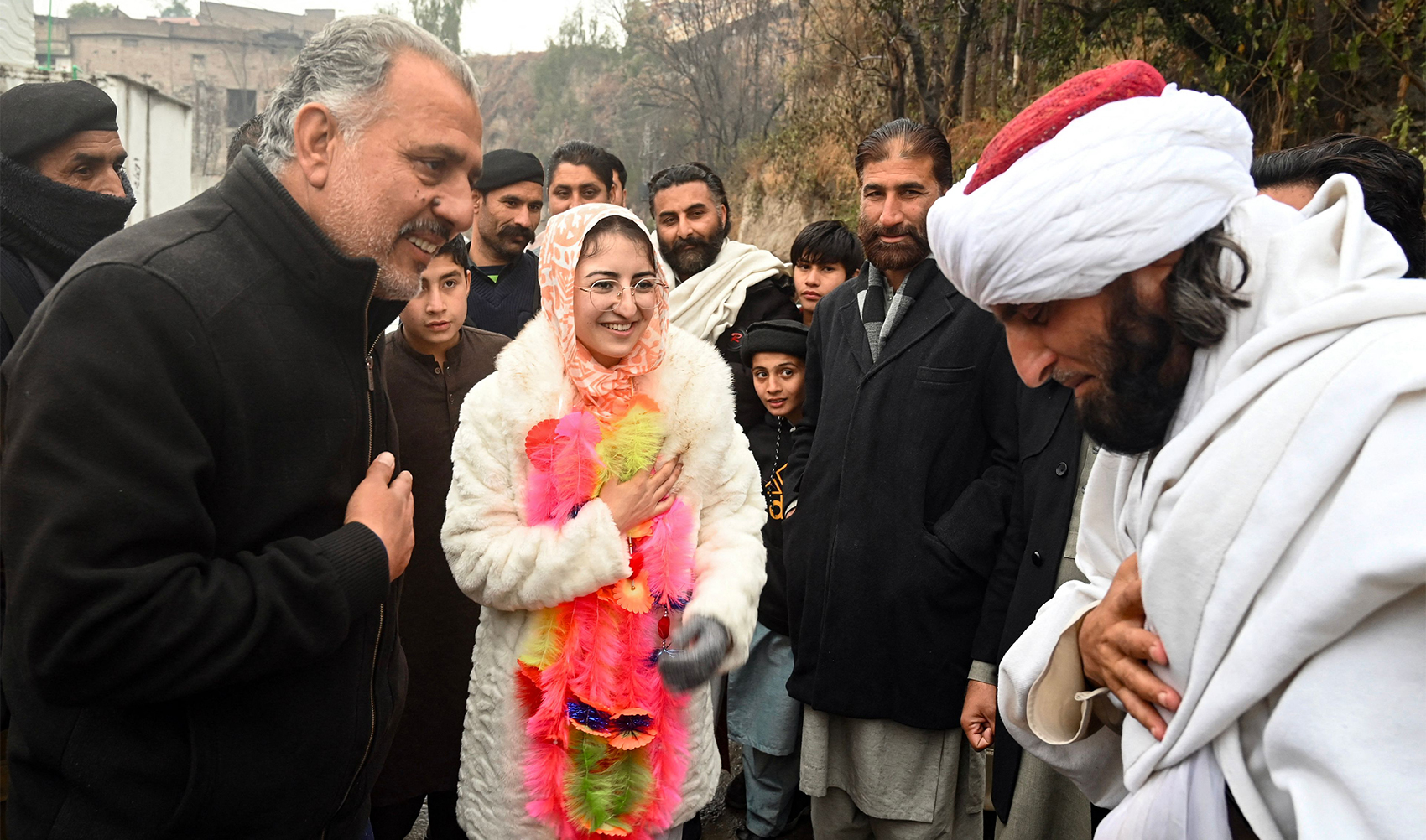 This photograph taken on January 31, 2024 shows Saveera Parkash (front C), a Hindu minority candidate of the Pakistan Peoples Party (PPP) for provincial assembly, greeting mufti Fazal Ghafoor (R), candidate of the Jamiat Ulema Islam-Fazal (JUI-F) party, during her election campaign rally in the Buner district of Khyber Pakhtunkhwa province. (AFP)