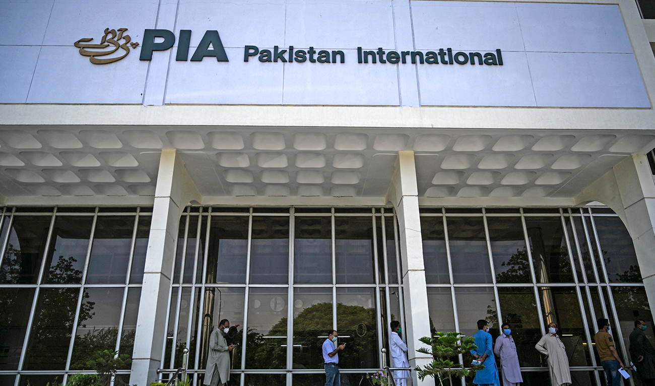 People stand in queue as they wait their turn to buy flight tickets outside Pakistan International Airlines (PIA) office in Islamabad on July 1, 2020. (AFP/File)