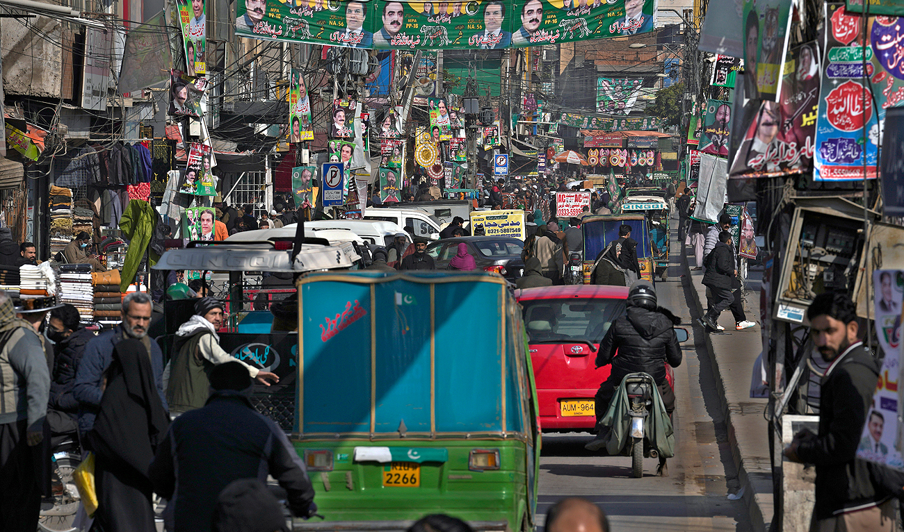 Banners of election candidates from political parties are displayed at a market downtown in Rawalpindi on February 6, 2024. (AP)
