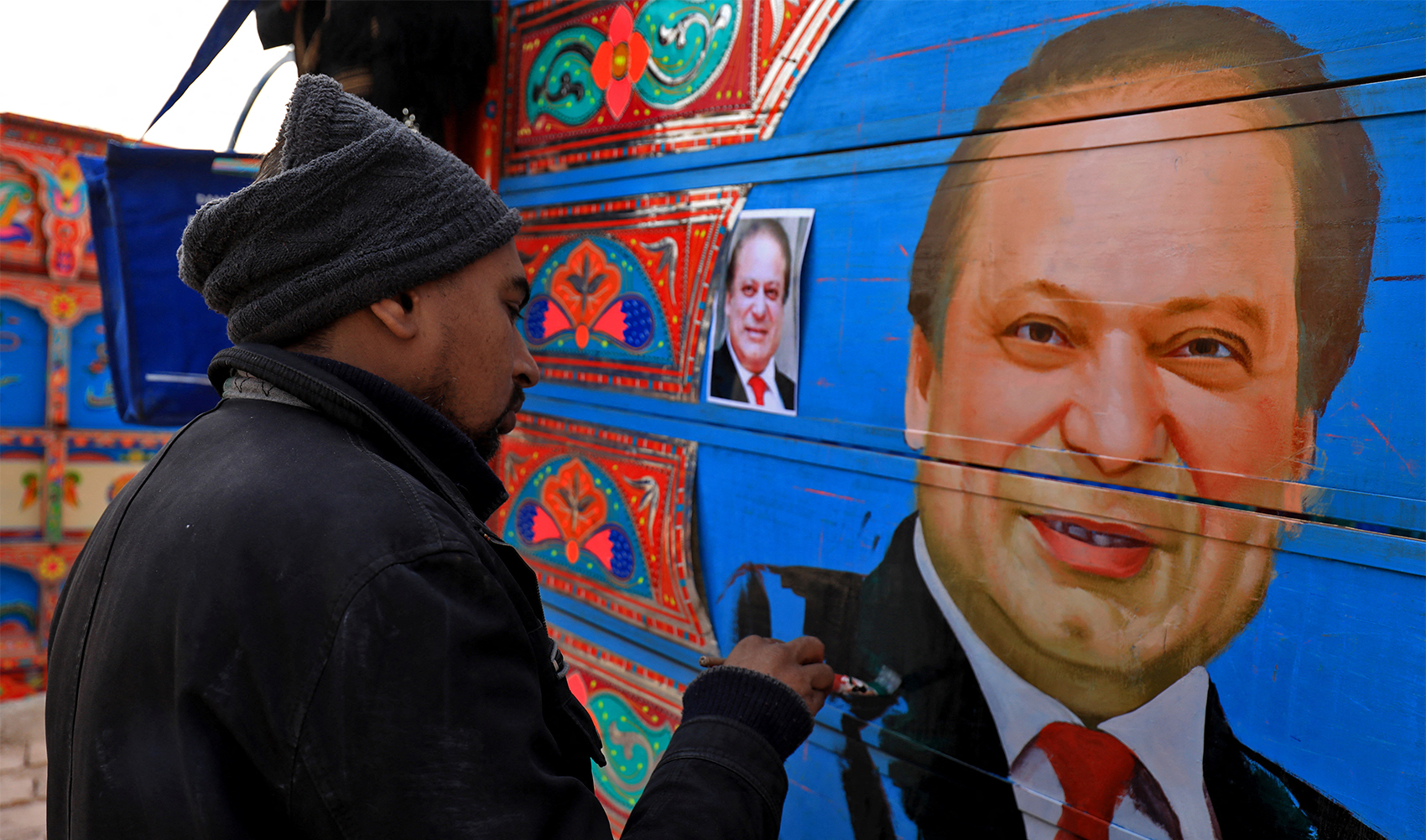 Sohail Ghuri, 40, a truck art painter, applies the final touches to a portrait of former Prime Minister Nawaz Sharif on wooden planks in the back of a truck at a workshop in Peshawar, Pakistan, on December 12, 2023. (REUTERS)