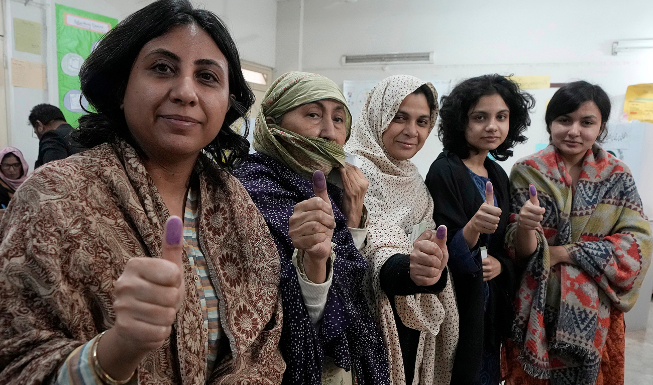 Women show their marked thumbs after casting their vote at a polling station during the country's parliamentary elections in Karachi, Pakistan, Thursday, Feb. 8, 2024. (AP)