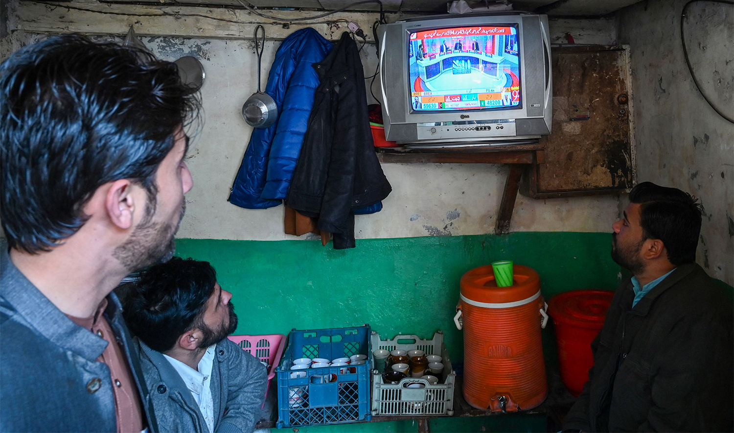 People monitor latest election results live on a television at a tea shop, a day after Pakistan's national elections in Lahore on February 9, 2024. (AFP)