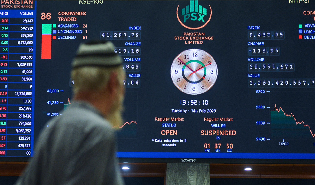 A broker looks at an index board showing the latests share prices at the Pakistan Stock Exchange in Karachi on February 14, 2023. (AFP/File)