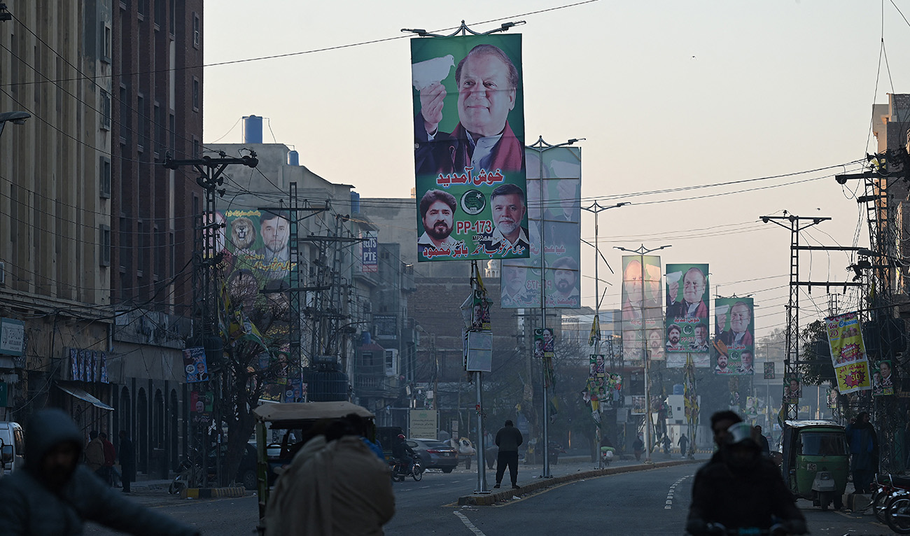 Commuters ride past election posters of former Pakistan's prime minister Nawaz Sharif, the leader of Pakistan Muslim League Nawaz (PMLN) party, display on a street a day after Pakistan's national general election in Lahore on February 9, 2024. (AFP/File)