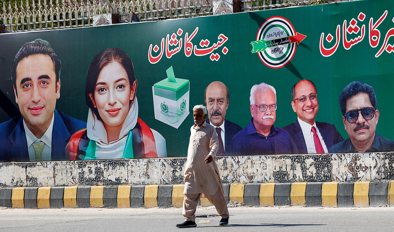 A man walks next to a billboard displaying photos of politician Bilawal Bhutto and his sister Asifa Bhutto, a day after general elections in Karachi, Pakistan February 9, 2024. (REUTERS)