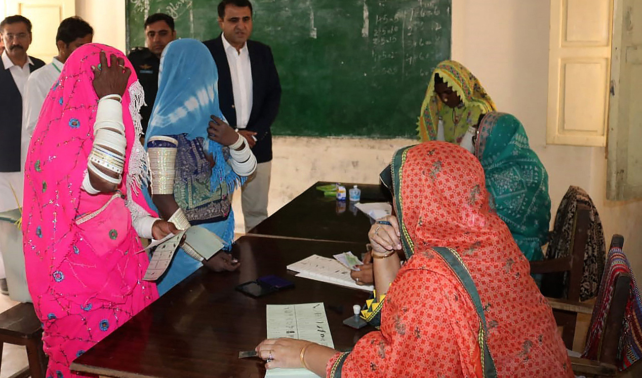 Women wait to get ballot papers from a polling officer to cast their vote at a polling station during Pakistan's national elections in Mithi on February 8, 2024. (AFP)