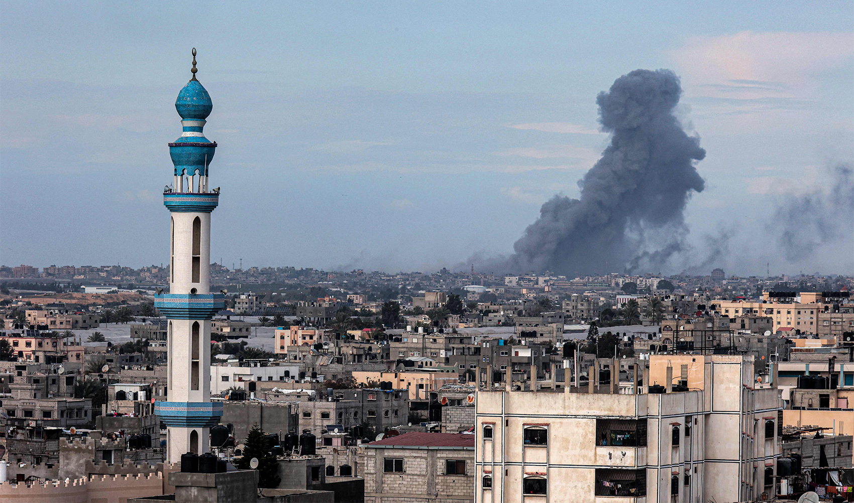 This picture taken from Rafah shows smoke billowing over Khan Yunis in the distance following Israeli bombardment on the southern Gaza Strip on February 14, 2024. (AFP)